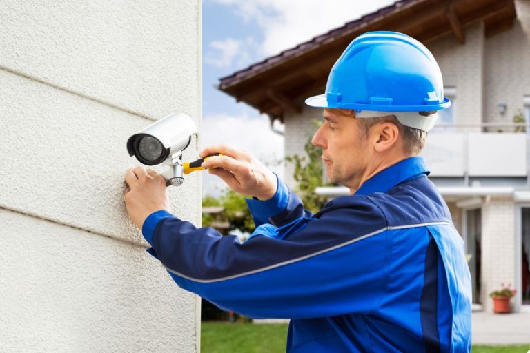 A construction worker in a hardhat is seen holding a camera, prepared to document his surroundings.