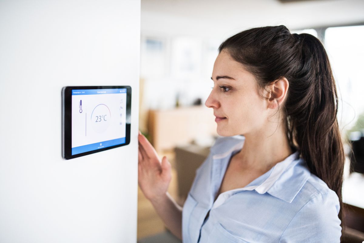 A woman gazes thoughtfully at a smart home device, contemplating its features and functionality in her modern living space.
