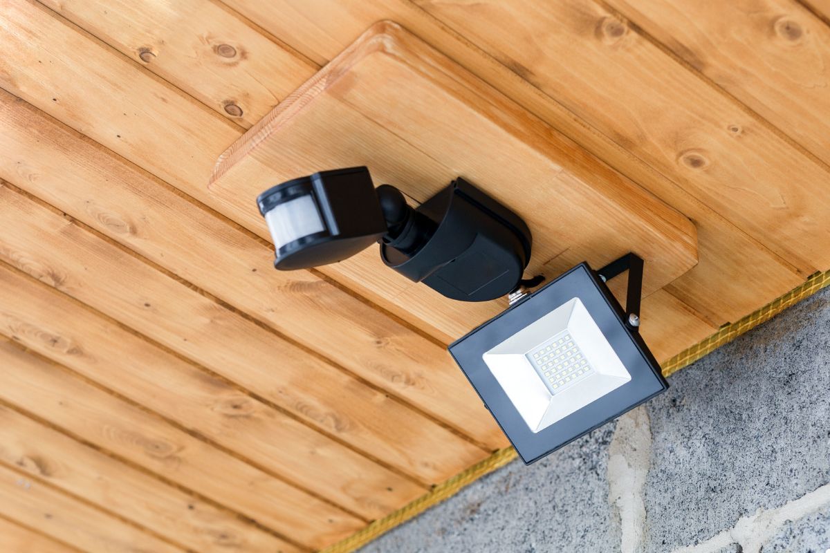 Security light affixed to a wooden wall, providing illumination and enhancing safety in the area.