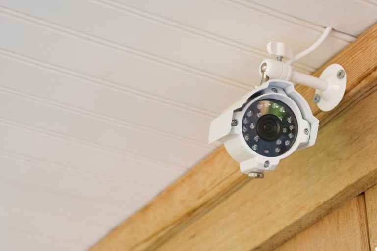 Security camera mounted on a house wall, monitoring the surrounding area for safety and surveillance.